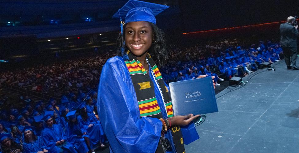 Student holding diploma at commencement.