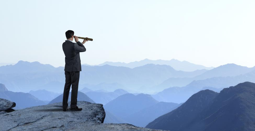 Man searching via telescope across a distant horizon