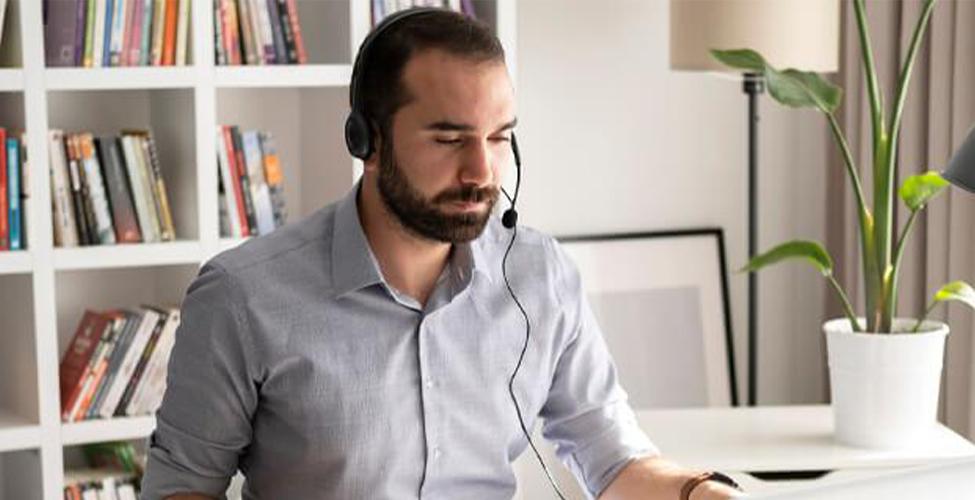 male looking at computer with headset