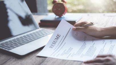 Editing a paper resume at a desk