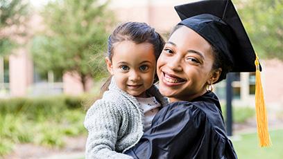 college graduating mother holding her child