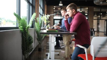 Men in an office working at standing desks