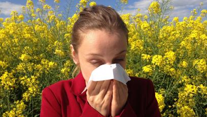 Sneezing woman in a flower field