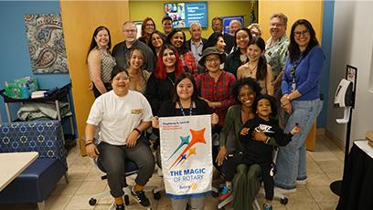 group gathers to pose with the Rotaract Club banner