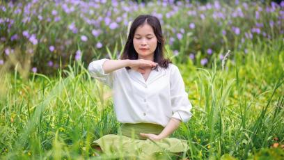 Woman meditating in a grassy field