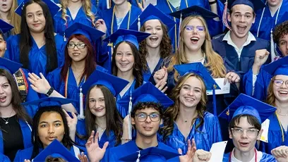 A large, energetic group of dual enrollment students from Rio Salado College cheer and smile during commencement. They are dressed in bright blue graduation gowns and caps, some holding diplomas and raising their hands in celebration. The diverse group of young graduates stands close together, radiating excitement and pride as they mark this academic milestone.