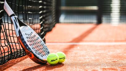 A tennis racket and balls on a court