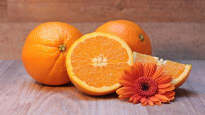 Four oranges and an orange-colored flower
