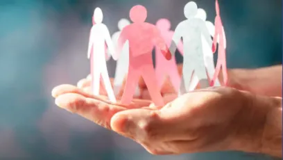 Hand holding up a circle of interconnected paper dolls