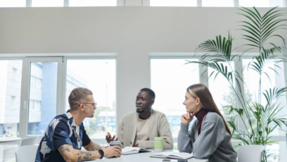 Three people sitting around an office table
