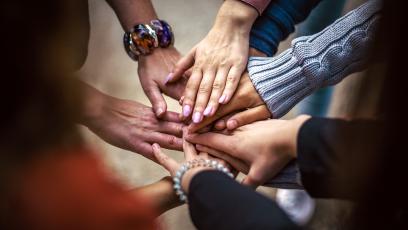 A circle of hands touching in the middle