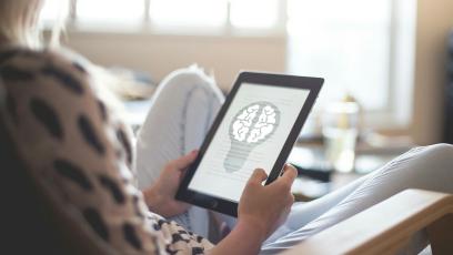 Woman using tablet with image of brain on it