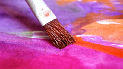 Brush painting magenta on a canvas