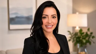 **Alt text:** Portrait of Kelly Sukkha smiling and wearing a black blazer in a professional indoor setting.