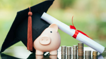 A piggybank wears a graduate's cap next to a diploma and stacks of coins