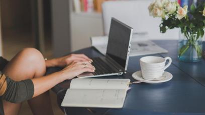 A woman studying with a laptop and notebook