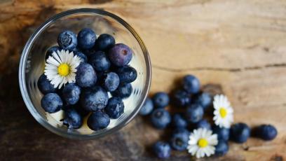 Blueberries in a bowl with daisies