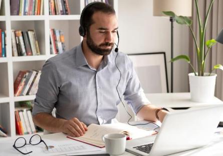 male looking at computer with headset