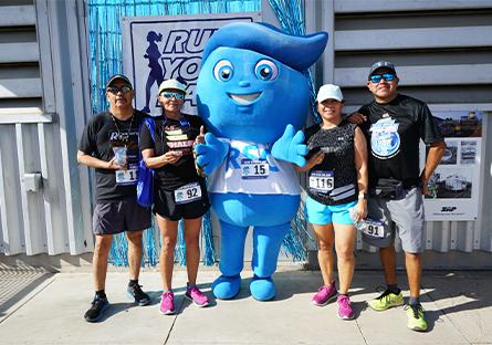 runners from 2022 Dash event posing with Splash mascot