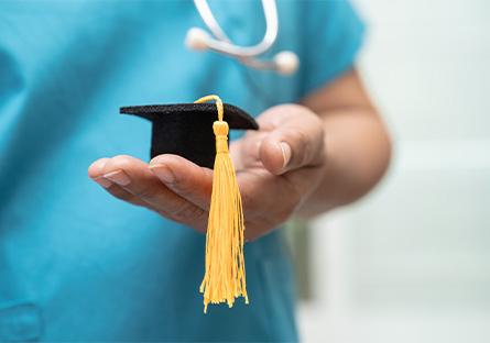 image of nursing student holding a miniature felt grad cap 