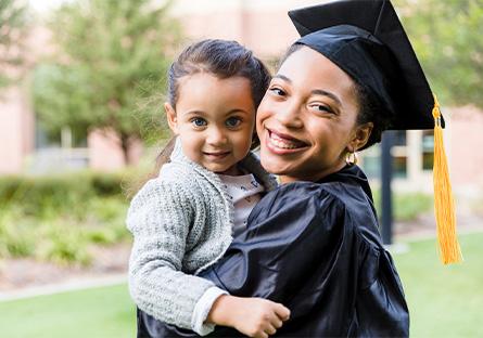 college graduating mother holding her child