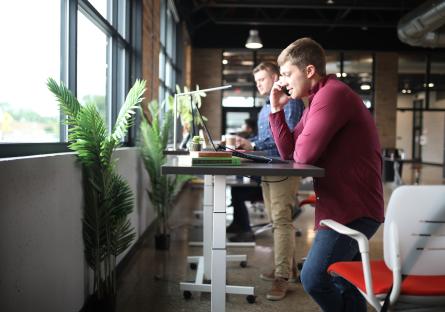 Men in an office working at standing desks