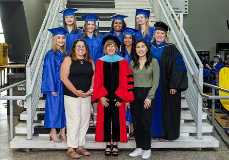 graduates from the program pose with Jennifer Gresko and Kate Smith at the 2023 commencement ceremony