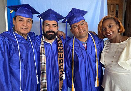 image of graduates posing with a staff member