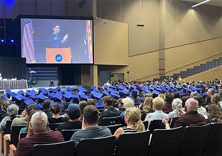 Attendees and HSE graduates listen to a speaker at the podium during the graduation ceremony