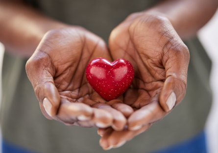 A pair of hands holding a sparkling heart