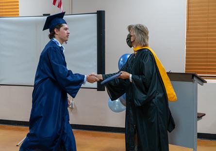 President Smith congratulates dual enrollment graduate at Heritage Academy watch party.