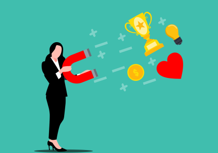 A woman with a big magnet drawing trophies, hearts, and coins toward her