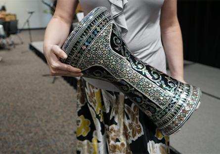 The instrument in the photo is a darbuka, also known as a doumbek, derbake, or tabla in different regions. It is a goblet-shaped hand drum commonly used in Middle Eastern, North African, and Eastern Mediterranean music. The one shown here is ornately decorated, often characteristic of high-quality ceremonial or performance drums.