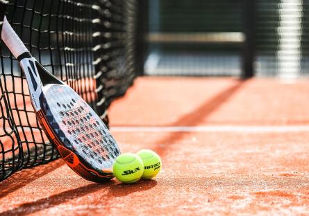A tennis racket and balls on a court