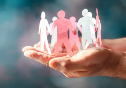 Hand holding up a circle of interconnected paper dolls
