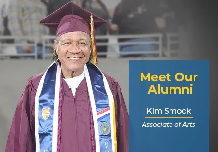 Kim Smock, a Rio Salado College graduate, smiles while wearing a maroon cap and gown with a white stole and several graduation medallions. Text beside the photo reads: “Meet Our Alumni – Kim Smock, Associate of Arts.” The image celebrates his academic achievement and Rio Salado College pride.