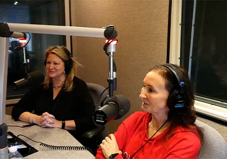 Robin Arredondo-Savage, president and CEO of the Tempe Chamber of Commerce, and Lisa Hausz, program manager in the City of Tempe’s economic development division, sit in a recording studio wearing headphones and speaking into microphones during Rio Salado College’s Wave Makers podcast.