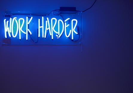 Neon lights spelling the words WORK HARDER