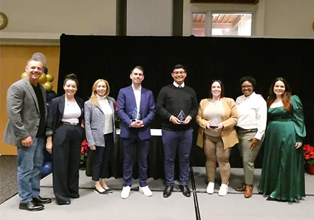 Group of Rio Salado College Phi Theta Kappa members and advisors standing on stage holding awards during a recognition event.