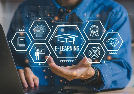 Person using a laptop with digital e-learning icons, including a graduation cap, certificate, instructor, brain, and target, displayed above an outstretched hand with the text “E-Learning.”