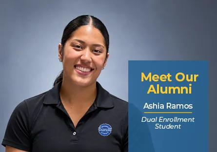 A promo graphic with a medium blue vertical block on the right overlaying a light gray studio background. On the left, Ashia Ramos smiles directly at the camera, wearing a black polo shirt with a round Nothing Bundt Cakes logo on the left chest. Her dark hair is styled back in a low pony. On the blue block, bold yellow text reads "Meet Our Alumni" above white text that reads "Ashia Ramos" underlined in yellow, followed by italicized text that reads "Dual Enrollment Student."