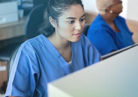 photo of a medical assisting student looking at a computer. Rio Salado College and Phoenix college logos.