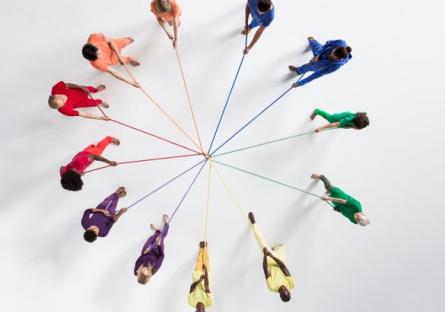 A circle of people holding strings connecting each other