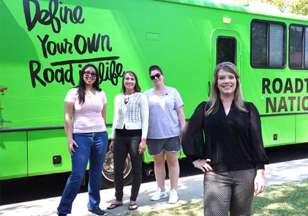 photo of three Roadtrip Nation students standing next to RV, with alum standing in the foreground