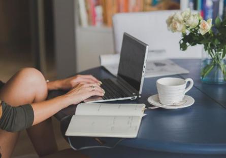 Woman studying with a laptop and a notebook