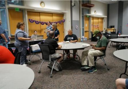 Veterans and volunteers sitting at a table at the dental event