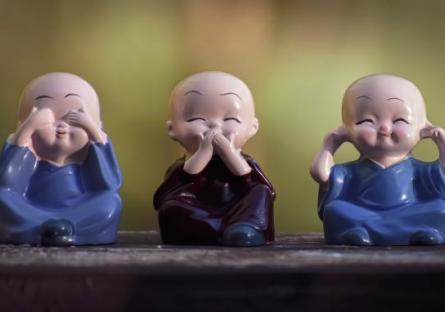 Three monk figures doing "say no/see no/hear no evil"
