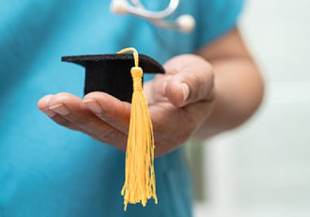 image of nursing student holding a miniature felt grad cap 