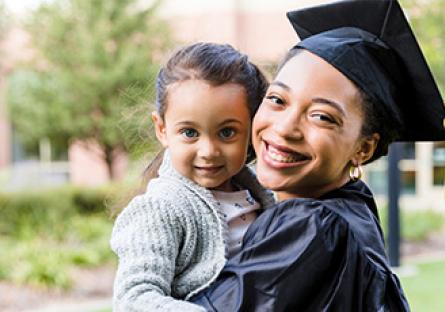 college graduating mother holding her child