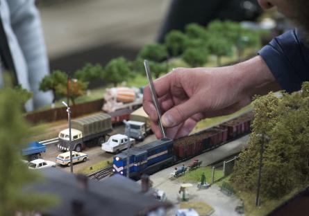 A hand works on a model train set
